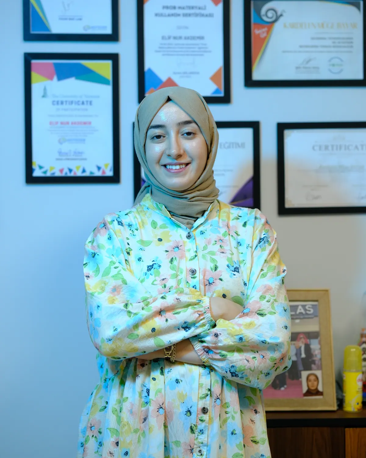 Uzm. Dil ve Konuşma Terapisti Elif Nur ÇİÇEK, sertifikalarının önünde